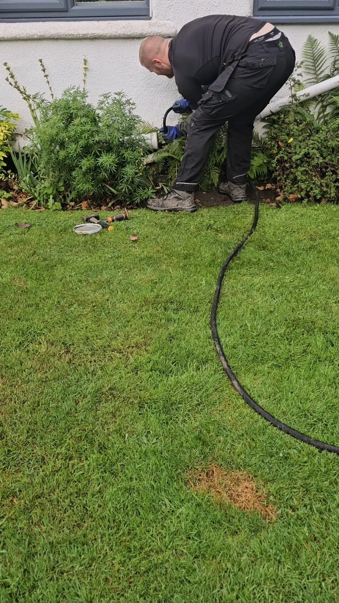 Drainage engineer clearing a blocked outdoor drain